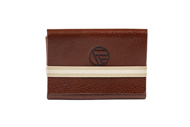 Porte-cartes en cuir marron avec élastique beige et logo circulaire gravé au centre.