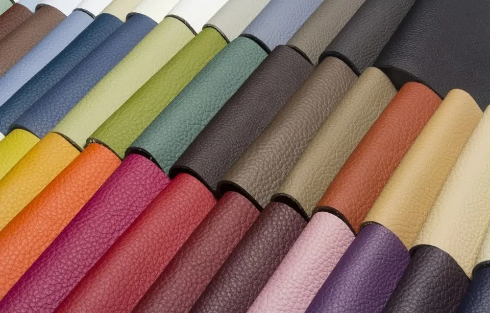 Échantillons de cuir colorés disposés en rangées, montrant une variété de textures et de teintes vives.