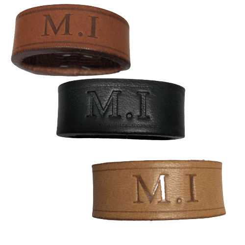 Trois bracelets en cuir avec les initiales "M.I" gravées, en marron clair, noir et beige.